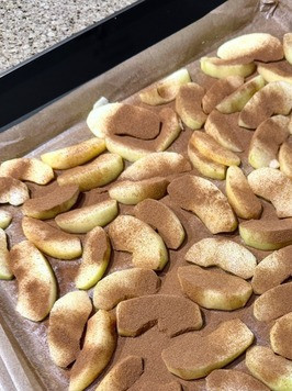 1. Этап. Яблочный рулет: Застелил противень пергаментом. Смазал его слегка сливочным маслом и яблоки ровным слоем на пергамент выложил. Сверху корицей молотой присыпал. Говорят, помимо цвета еще и вкус с аромат прибавляет. В общем, навредить не должно.