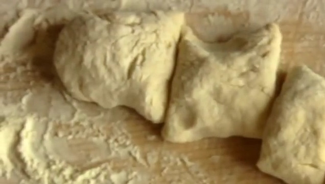 1. Этап. Жареные пирожки с вишней на кефире: 4. Острым ножом разделите тесто на 3 части, скатайте жгуты. Нарежьте их порционными кусочками.