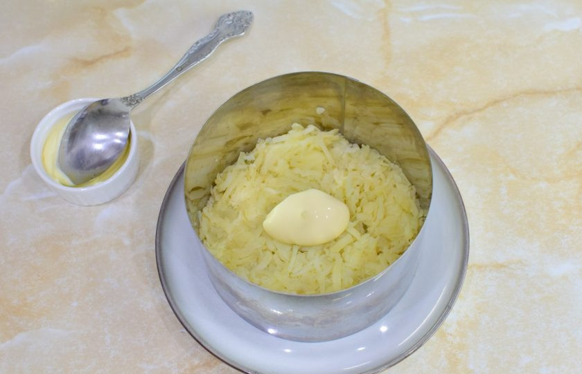 1. Этап. Салат Сельдь под шубой: Собирать салат будем слоями. Можно в общем салатнике или в кольце. Первым слоем салата выложите тертый картофель. Немного смажьте его майонезом.