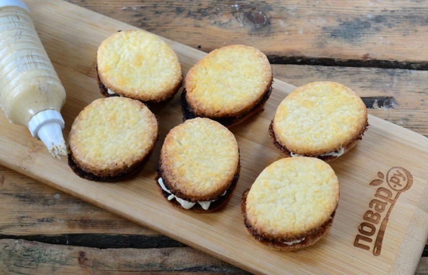 1. Этап. Мокко овальчики: Наполните кондитерский шприц или мешок кремом, выдавите большое количество крема на каждую печенюшку, сложите их вместе.