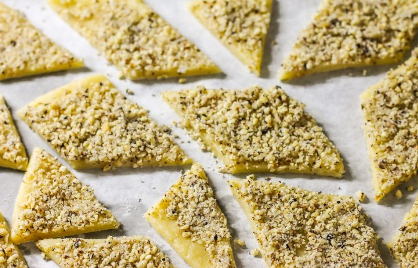 1. Этап. Печенье с грецкими орехами: Нарежьте тесто ромбиками. Выстелите пергаментной бумагой противень и выложите на него ромбики. Поместите противень в духовку и выпекайте десерт около 12-15 минут до румяности.