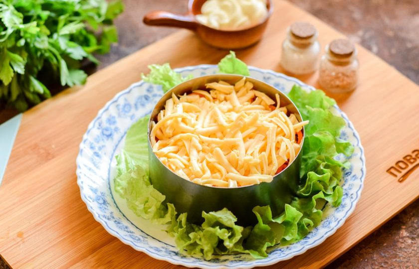 1. Этап. Салат Буррито: Твердый сыр натрите на средней терке и выложите поверх моркови. Смажьте слой майонезом.