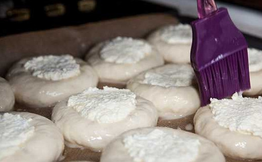 1. Этап. Королевские ватрушки с творогом: 10. Оставшееся яйцо взбейте с небольшим количеством молока или водички. С помощью кисточки промажьте тесто со всех сторон.