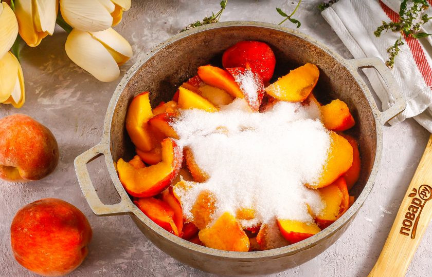 1. Этап. Персики в желе с желатином на зиму: Нарежьте мякоть персиков ломтиками в казан или кастрюлю с антипригарным дном. Всыпьте сахарный песок. По желанию можете добавить немного лимонной кислоты или лимонного сока. Аккуратно перемешайте. Поместите емкость на плиту.