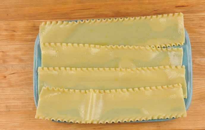 1. Этап. Рулеты с грибами и шпинатом: 1. В подсоленной кипящей воде отварите листья для лазаньи в течение 8 минут. Затем промойте их холодной водой, обсушите и смажьте 1 ч. ложкой масла.