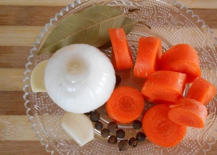 1. Этап. Cвиная рулька по-немецки: Лук и чеснок чистим от шелухи, чеснок режем пополам, а в луковице делаем крестообразный надрез. Морковь чистим и нарезаем толстыми кружочками.