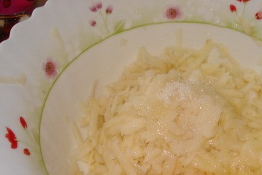 1. Этап. Латкес с клюквенно-яблочным соусом: Займемся оладьями. Картофель натрем на крупной терке, репчатый лук на мелкой, добавим куриное яйцо. Щепотку соли, пол-столовой ложки сахара и муку.