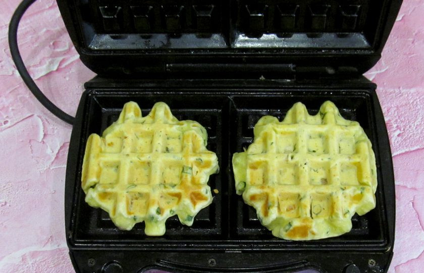 1. Этап. Вафли с курицей и зелёным луком: Разогрейте электровафельницу с толстыми пластинами. Выкладывайте тесто столовой ложкой, используя для каждой вафли 1,5-2 ст. л. теста. Готовьте вафли до румяной корочки.