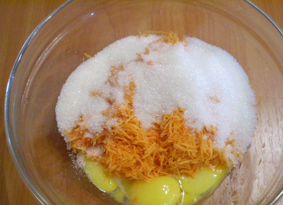 1. Этап. Морковный пирог в мультиварке: Берем глубокую посудину. Насыпаем туда сахар, добавляем тертую на мелкой терке морковь и желтки яиц. Перемешиваем.