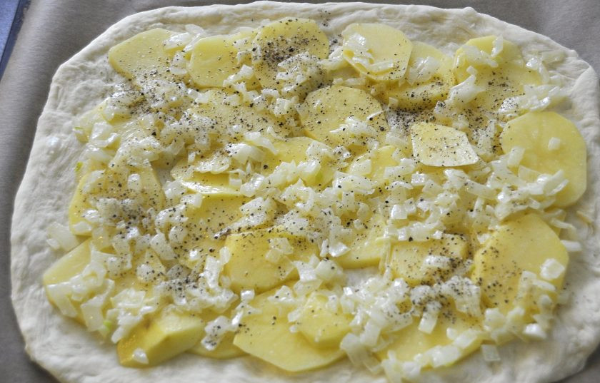 1. Этап. Пирог с зубаткой: Выложите тесто на лист для выпечки, на тесто кружочки картофеля, не забудьте слегка присолить, на картофель выложите лук, поперчите.