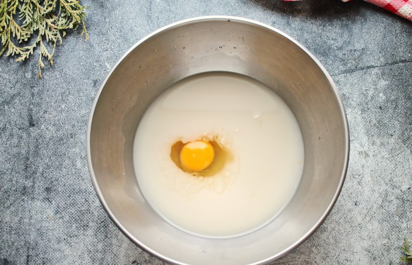 1. Этап. Чесночные булочки в духовке из дрожжевого теста: В миску налейте теплое молоко, теплую воду, всыпьте соль, сахар, раскрошите дрожжи и перемешайте до полного растворения. Разбейте в миску яйцо, влейте растительное масло и перемешайте до однородности.