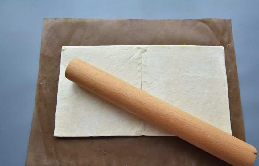 1. Этап. Штрудель с яблоками и брусникой: Замороженное слоеное тесто предварительно разморозьте и раскатайте в прямоугольный пласт, толщиной 1-2 мм. Чтобы тесто не прилипало к поверхности присыпьте его небольшим количеством кукурузного крахмала. Удобно раскатывать тесто на силиконизированноом коврике, на котором штрудель будет выпекаться.