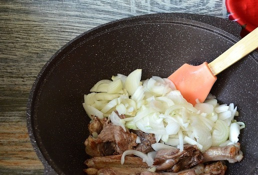 1. Этап. Плов с уткой: В казане хорошо разогреть растительное масло, убавить огонь до среднего, обжарить в масле куски утки. Добавить нарезанный репчатый лук, жарить 5-7 минут на среднем огне.