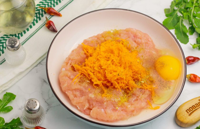 1. Этап. Куриные котлеты в аэрогриле: Вбейте куриное яйцо, всыпьте приправу и молотый черный перец. Если любите еще какие-нибудь специи и пряности, то добавьте по своему вкусу. Тщательно все перемешайте.