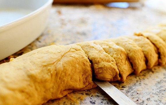 1. Этап. Тыквенные булочки с корицей и орехами: 6. Скрутите тесто в рулет, поделите на несколько частей.