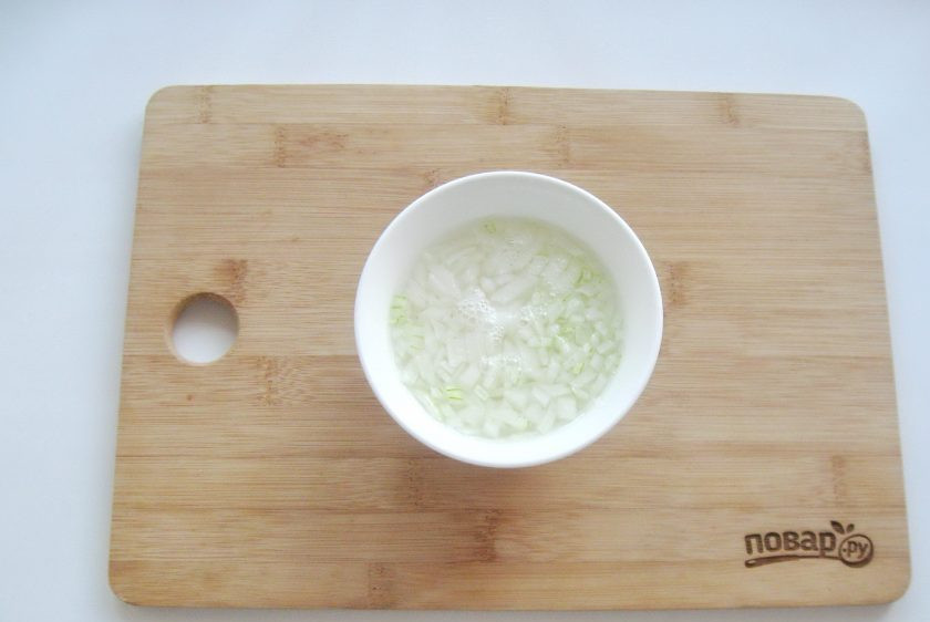 1. Этап. Салат Рыбки в пруду со шпротами: Репчатый лук очистите, помойте и мелко нарежьте. Выложите в миску и залейте кипятком, чтобы ушла горечь. Оставьте лук в кипятке на 10 минут, после воду слейте.