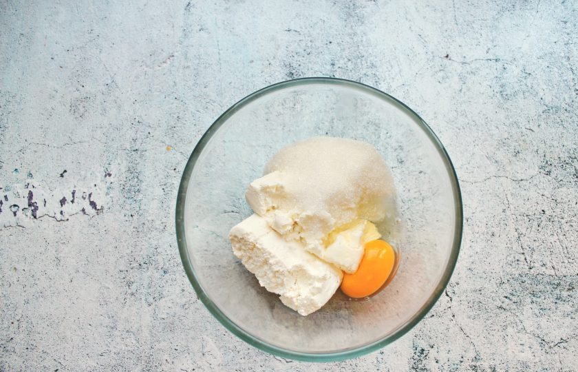 1. Этап. Сырники с топинамбуром: В миску выложите творог и разбейте яйцо, всыпьте сахар.