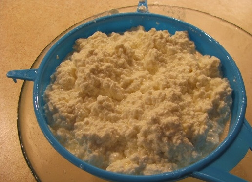 1. Этап. Рецепт домашнего сыра из молока и творога: Откидываем створоженную массу на сито, пусть лишняя жидкость стечет и масса остынет.