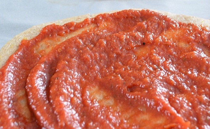 1. Этап. Овощная пицца с моцареллой: 3. Нанесите на каждый корж для пиццы по ¼ стакана томатного соуса.