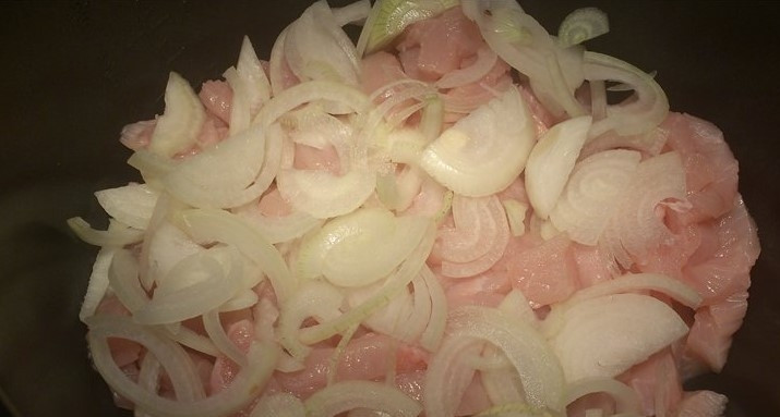 1. Этап. Грудка индейки в мультиварке Редмонд: Филе индюшки промойте в холодной воде и нарежьте небольшими кусочками. Лук почистите и порежьте полукольцами. Мясо и лук выложите в чашу мультиварки.