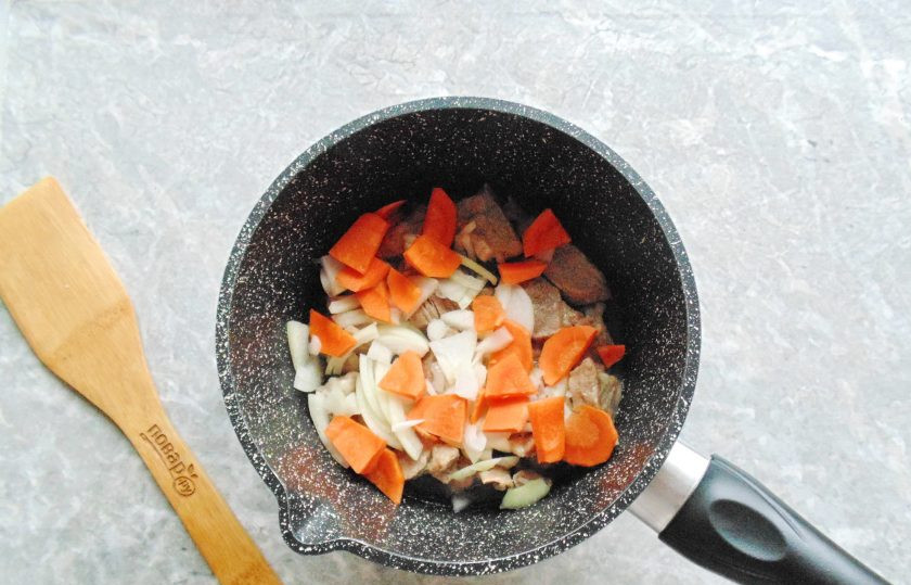 1. Этап. Гуляш с горохом: Лук и морковь очистите, помойте, нарежьте произвольно, но не крупно. Выложите в сотейник к мясу. Обжарьте овощи с мясом до прозрачности лука.