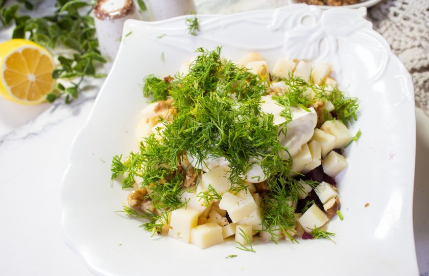 1. Этап. Салат со свеклой, сыром и яблоком: В салатник добавьте мелко нарезанную зелень, сметану, соль и черный молотый перец. Перемешайте салат.