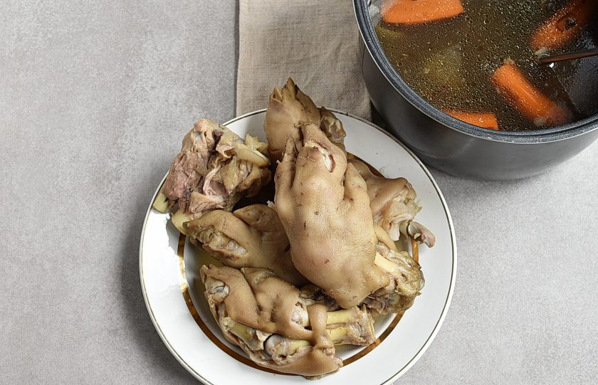 1. Этап. Холодец из свиных ножек в мультиварке: Выложите ножки на тарелку. Процедите бульон. Обмакните в бульон два пальца и плотно сожмите их. Если бульон достаточно липкий, клейкий, оставьте его в покое. Если жидковат — верните в мультиварку и уваривайте еще немного.