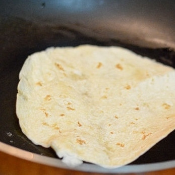 1. Этап. Энчиладас: 5. Нагрейте сковородку с маслом на среднем огне. Обжарьте тортильи на горячем масле с двух сторон по 30 секунд с каждой стороны.