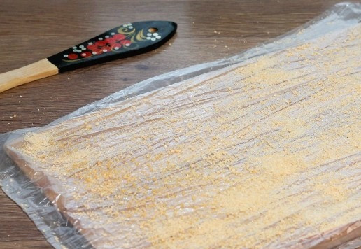 1. Этап. Картофельный рулет с консервированным тунцом: 9. Пищевую пленку (или пакет) кладем на разделочную доску и смазываем растительным маслом. Посыпаем панировочными сухарями (1 ст. л.).