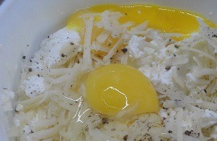 1. Этап. Зеленые равиоли с чесночным соусом: Для начинки соедините творожный сыр с натертым на терке пармезаном, яйцом, яичным желтком (белок понадобится попозже), свежемолотым черным перцем. По желанию можете слегка посолить.