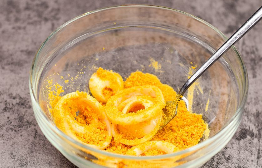 1. Этап. Обжаренные луковые кольца: Завершающий этап — переложите луковые кольца в миску с панировочными сухарями. Параллельно поставьте на огонь небольшую кастрюлю с растительным маслом, хорошо подогрейте масло.