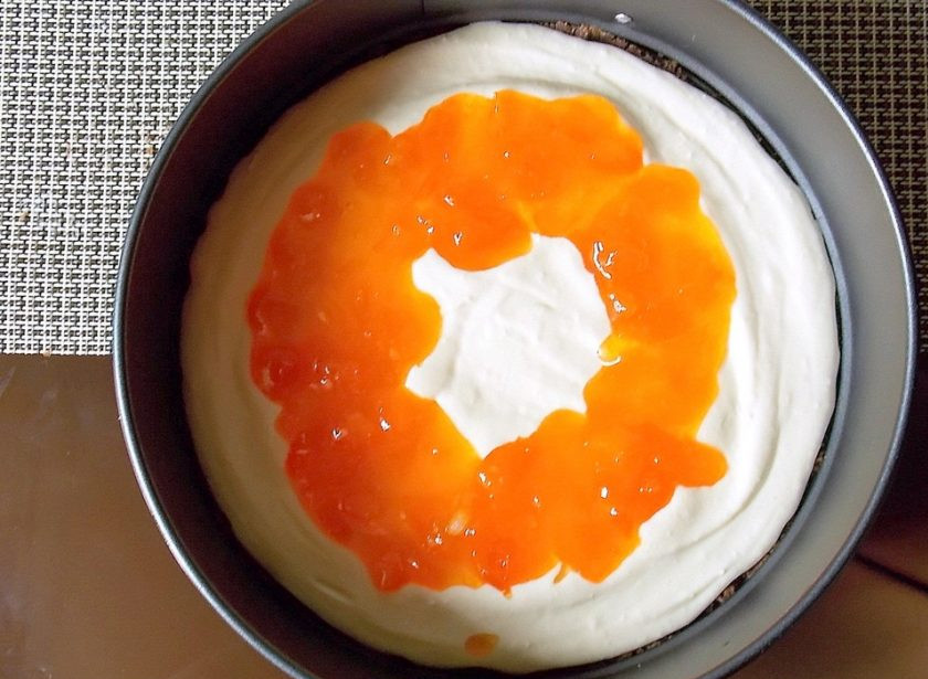 1. Этап. Торт с джемом и сыром Филадельфия: Положите половину массы на бисквитную основу. Джем уложите в виде кольца.