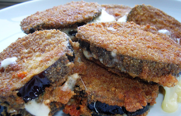 1. Этап. Баклажаны с сыром и чесноком: 6. Позвольте баклажанам в панировке высохнуть (в течение 10 минут), а пока на средне-высоком огне нагрейте в сковороде масло. Жарьте баклажаны с сыром и чесноком с двух сторон по 2-3 минуты с каждой. Приятного аппетита!