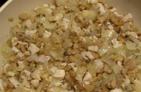 1. Этап. Фаршированные грибы в мультиварке: Далее мы нарезаем мелко куриное филе и обжариваем его до золотистого цвета на растительном масле. Затем добавляем к мясу измельченный репчатый лук и ножки шампиньонов, жарим все еще минут 5. Потом выкладываем на сковороду сметану, перемешиваем все и тушим начинку под крышкой несколько минут.