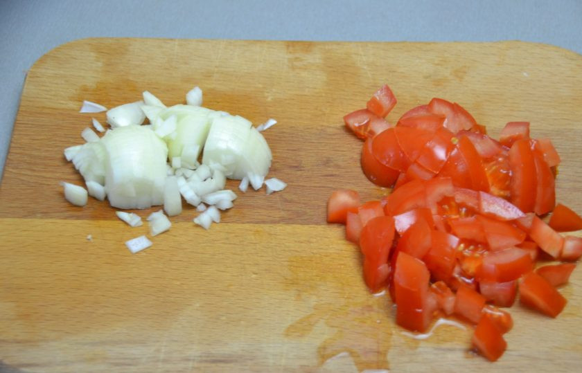 1. Этап. Овощной суп с гречкой: Порежьте мелким кубиком лук и помидор.