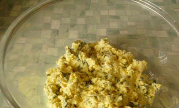 1. Этап. Салат Гнездо глухаря с грибами: Теперь сделайте массу для оформления. Смешайте желтки с сыром, зеленью и половиной чеснока. Заправьте массу салатом. Отправьте её в холодильник на 6 минут.