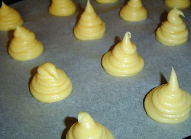 1. Этап. Профитроли с красной рыбой: Застилаем противень пекарской бумагой и при помощи кондитерского мешка выкладываем на него профитроли. В принципе, форма нужна только для красоты, поэтому можно и просто выложить ложечкой.