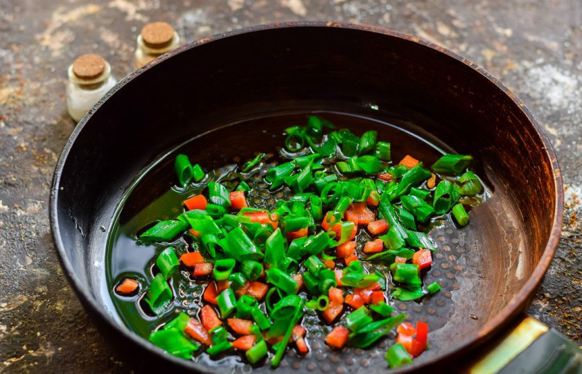 1. Этап. Лапша с креветками по-тайски: Креветки поставьте варить на 2 минуты, фунчозу запарьте в кипятке на 5 минут. Сковороду прогрейте с маслом, нарежьте зеленый лук, бросьте в сковороду, туда же добавьте чеснок нарезанный и чеснок. Жарьте пару минут все компоненты.