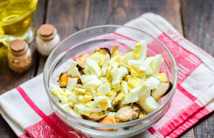 1. Этап. Салат с мидиями и морской капустой: Куриное яйцо сварите вкрутую, почистите и нарежьте кубиками, добавьте в салат.