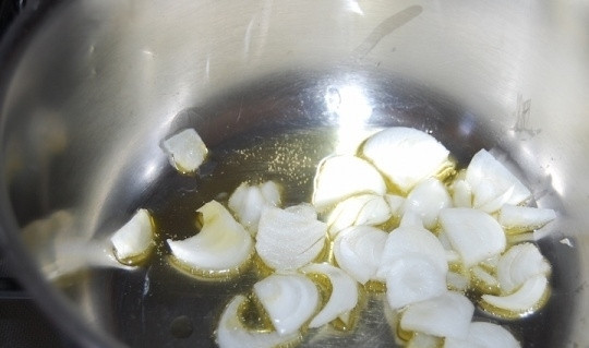 1. Этап. Вкусный суп-пюре: Картофель и лук почистите и промойте под холодной проточной водой. Репчатый лук нарежьте ломтиками и обжарьте в толстостенной кастрюле в небольшом количестве оливкового масла.