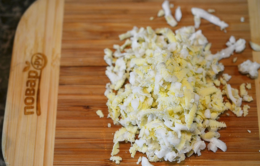 1. Этап. Новогодний салат Королевский: Яйца натрите на терке и положите следующим слоем и немного заправки.