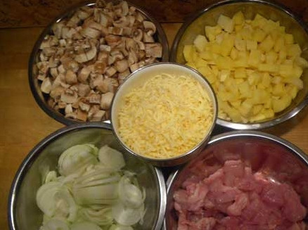 1. Этап. Тушеная картошка с курицей и грибами: Картофель и курицу нарежьте небольшими кубиками, лук – полукольцами, а сыр натрите на крупной обычной терке.