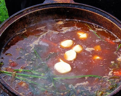 1. Этап. Шурпа из баранины в казане: Через 10 минут добавляем нут, картошку, зелень и все заливаем водой.