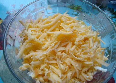 1. Этап. Салат Новогоднее чудо: 2. Дальше выкладываем тертый сыр и яйца (их можно либо порезать, как вам нравится, либо тоже натереть на терке). Перемешаем.