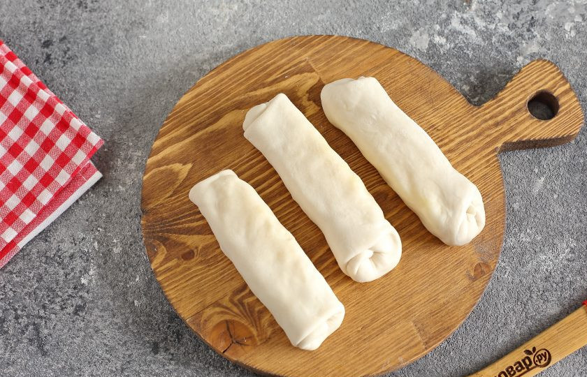 1. Этап. Рулетики из теста с картошкой: Подверните края с трех сторон, и сверните тесто с начинкой в рулет. Место шва хорошо защипните. Таким образом сформируйте все рулетики, пока не закончится тесто или начинка.