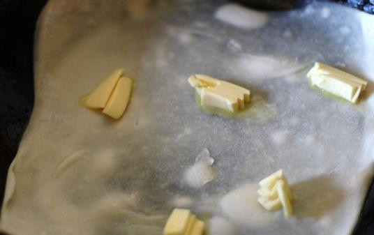 1. Этап. Спанакопита с щавелем: На первый тонкий лист теста выкладывается сливочное масло, затем накрывается еще одним листом теста. Далее идет слой начинки. Затем начинка накрывается еще несколькими тонкими листами теста. Верхний слой смазать водой или маслом.