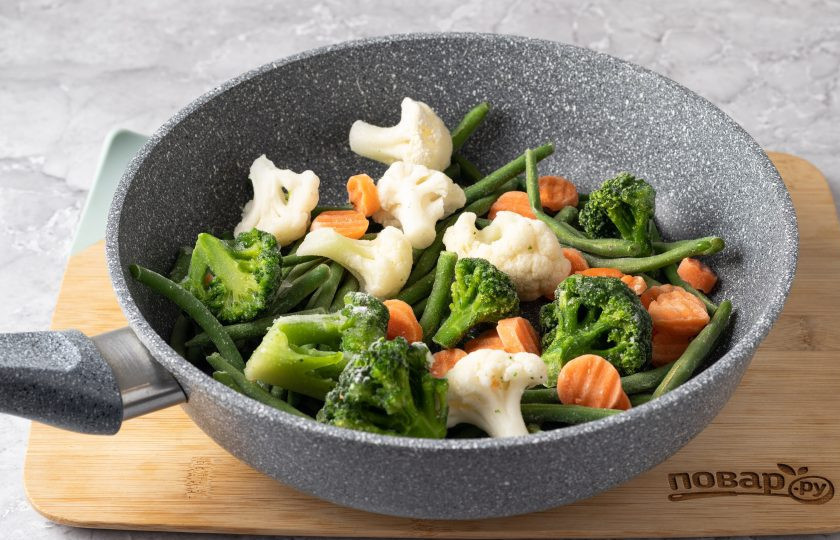 1. Этап. Замороженные овощи на сковороде: Выложите замороженные овощи в разогретую на среднем огне сковороду. Подержите их около 5 минут так, пока они постепенно не начнут размораживаться.