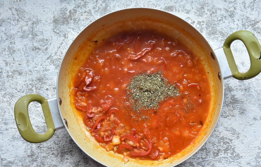 1. Этап. Курица по-кубински: В сковороде где обжаривалась курица пассеруйте нарезанный кубиком лук и болгарский перец до мягкости. Добавьте измельченный чеснок, орегано, лавровый лист, молотый тмин и томатную пасту. Через пару минут влейте вино и перемешайте до объединения. Уварите смесь в течение 2-3 минут.