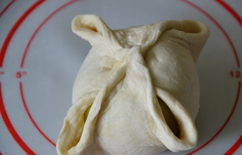 1. Этап. Яблоки в платочках: Соберите кончики теста к центру и хорошо защипните, чтобы при выпечке они не раскрылись.