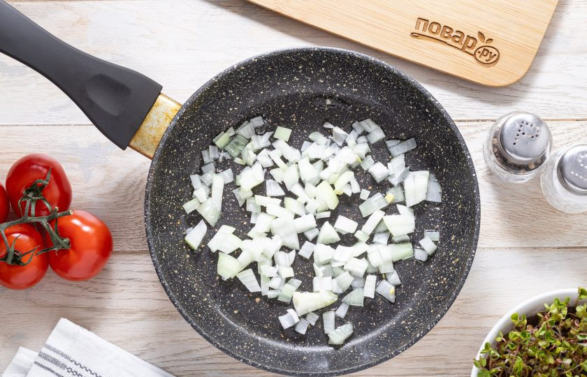 1. Этап. Фасоль по-египетски: Репчатый лук нарежьте кубиками. Разогрейте сковороду на среднем огне и обжарьте лук с растительным маслом около двух минут до мягкости и золотистого цвета.